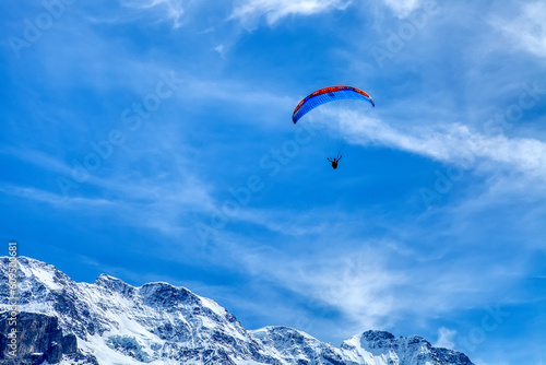 Paraglider in the blue sky. The sportsman flying on a paraglider. Leisure sports activity in holiday