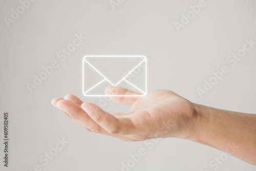 Email marketing and newsletter. Customer service call center contact us. Male hand holding letter or email icon. Contact us by newsletter email and protect your personal information from spam mail.