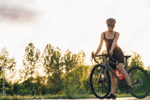 Portrait of a woman riding a bike during a sport cycling race outside of the city