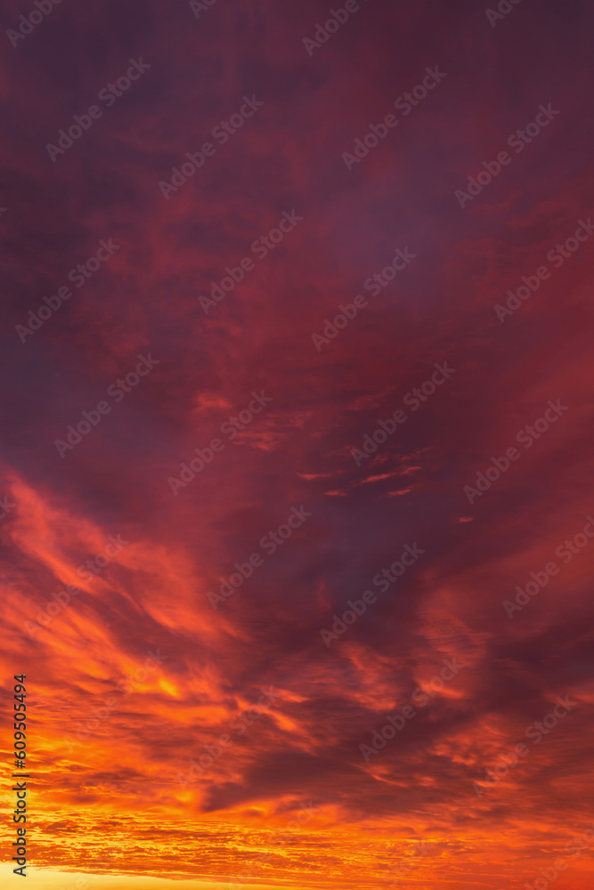 Epic dramatic sunrise, sunset orange red yellow clouds in sunlight abstract background texture