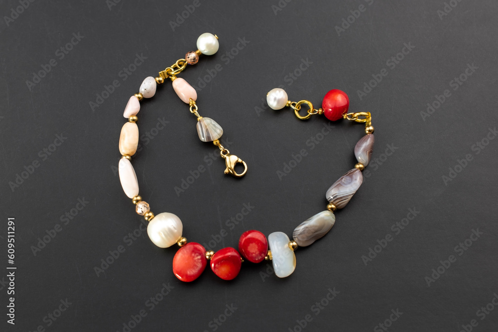 Beautiful red coral and pearl bracelet, unique handmade stone bead jewelry background, gemstone jewelry concept, promotional photo for an online jewellery store Beautiful red coral and pearl bracelet, unique handmade stone bead jewelry background, gemstone jewelry concept, promotional photo for an online jewellery store