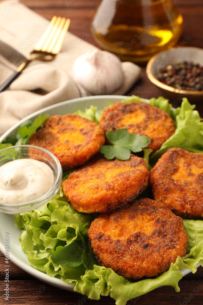 Tasty vegan cutlets with sauce on table, closeup