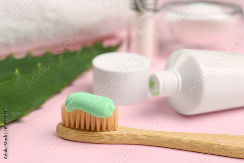 Toothbrush with aloe toothpaste on pink background  closeup