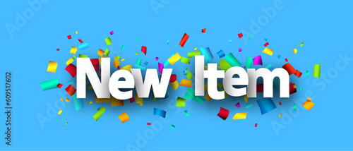 New item sign over colorful cut out ribbon confetti background.