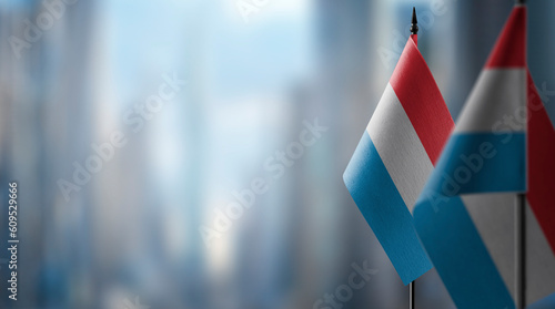 Small flags of the Luxembourg on an abstract blurry background