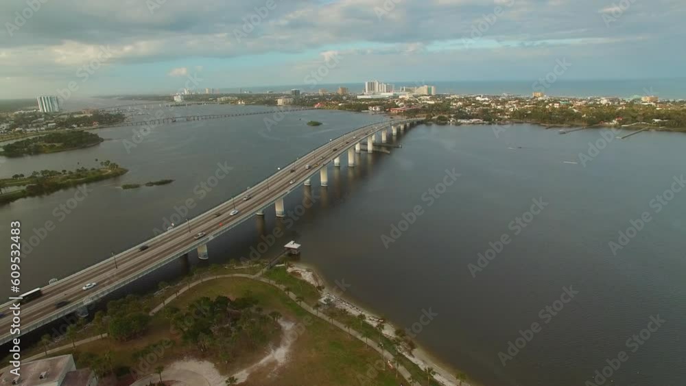 Aerial Panning Shot Of Bridges On Sea In City Against Cloudy Sky, Drone Flying Over Buildings - Daytona Beach, Florida Aerial Panning Shot Of Bridges On Sea In City Against Cloudy Sky, Drone Flying Over Buildings - Daytona Beach, Florida