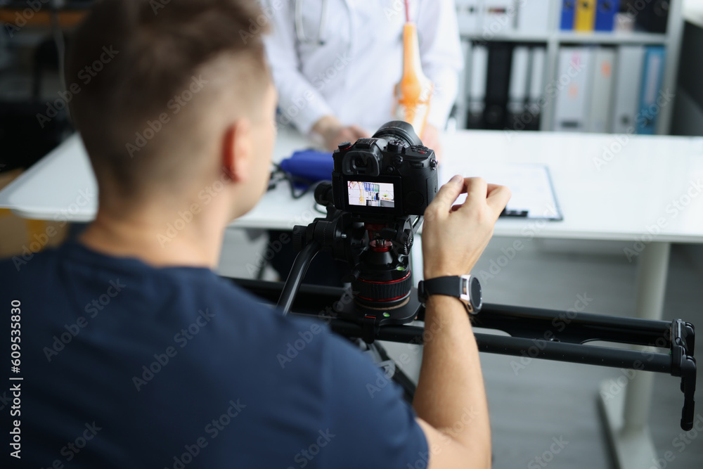 Videographer filming medical training on orthopedics doctor blogger. Remote medical consultations or filming with doctors