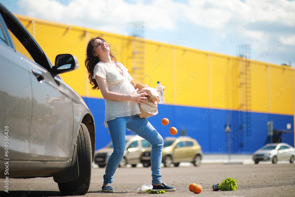 Pregnant woman with shopping comes from the store Pregnant woman with shopping comes from the store