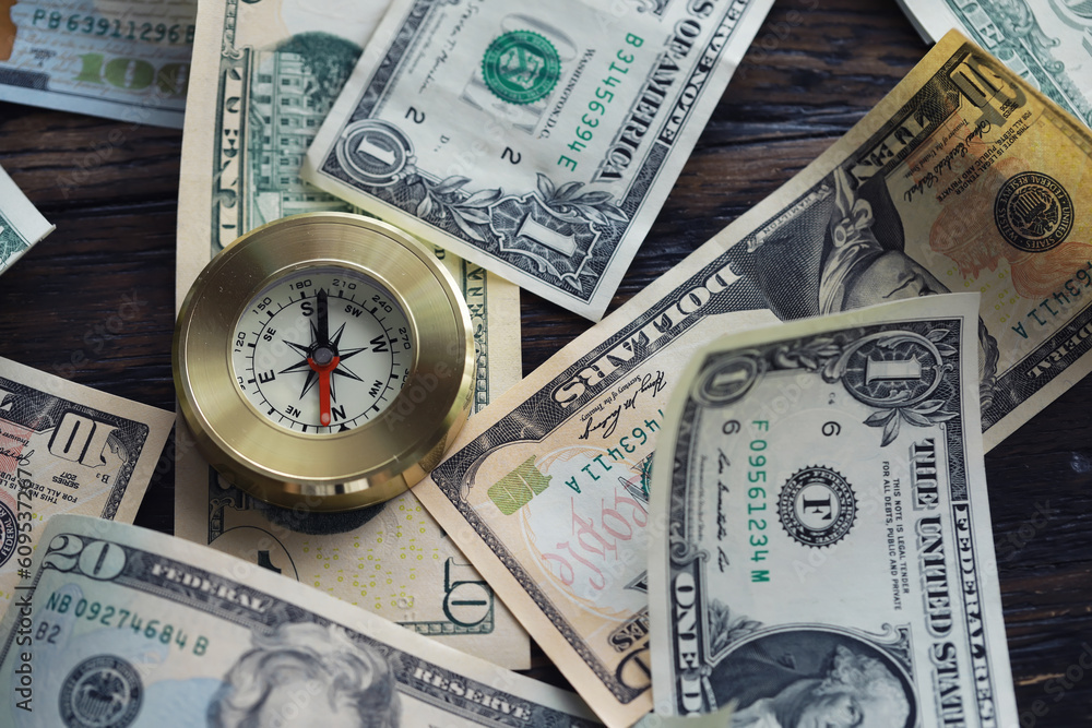 Money bill with golden Compass. Bullets and cartridge cases as a military concept. Close up US Currency and compass. business, financial idea, concept, symbol of crisis, inflation Money bill with golden Compass. Bullets and cartridge cases as a military concept. Close up US Currency and compass. business, financial idea, concept, symbol of crisis, inflation