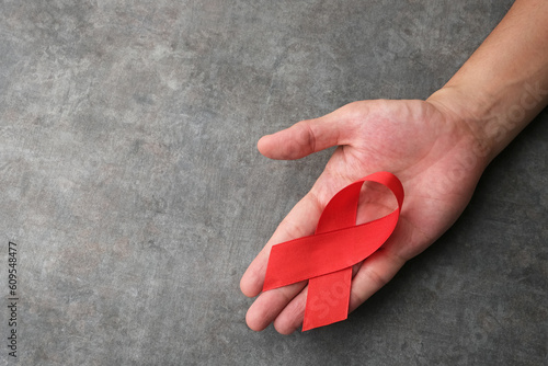 Hand holding Red Ribbon. World Aids Day and multiple myeloma Cancer concept
 photo