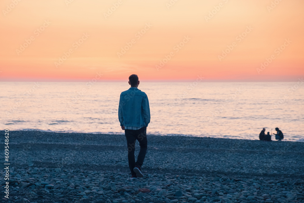 Lonely man walking on the sea coast at sunset. Male with mental ...