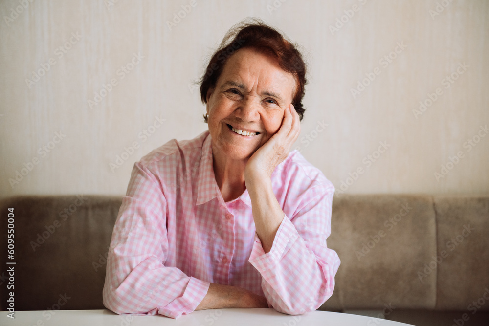 Portrait of happy senior lady sitting at home, closeup, copy space. Attractive old woman with short hair smiling at camera Portrait of happy senior lady sitting at home, closeup, copy space. Attractive old woman with short hair smiling at camera