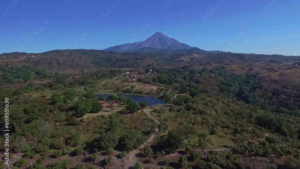 Vuelo de drone sobre un lago artificial teniendo de fondo el volcán de Colima, México. Vuelo de drone sobre un lago artificial teniendo de fondo el volcán de Colima, México.