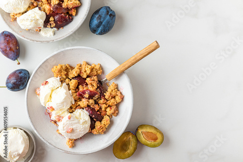 Billede på lærred Plum crumble with vanilla ice cream on white background