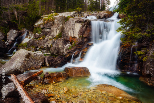 Stunning scenery of the rapids of a Dlhy waterfall flowing through rocky mountains in a green forest. National Park High Tatra  Slovakia 