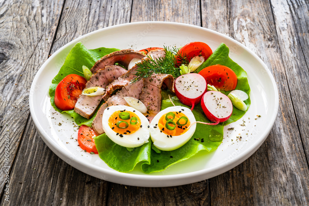 Tasty salad - roasted beef loin boiled eggs and fresh vegetables on wooden table
Tasty salad - roasted beef loin boiled eggs and fresh vegetables on wooden table