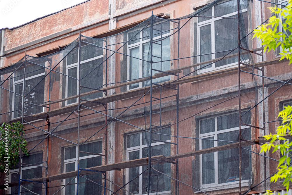 A fragment of the facade of the building under reconstruction on a summer day A fragment of the facade of the building under reconstruction on a summer day