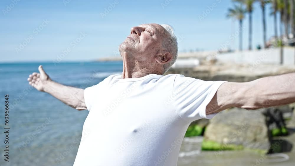 Senior grey-haired man breathing with closed eyes at seaside Senior grey-haired man breathing with closed eyes at seaside