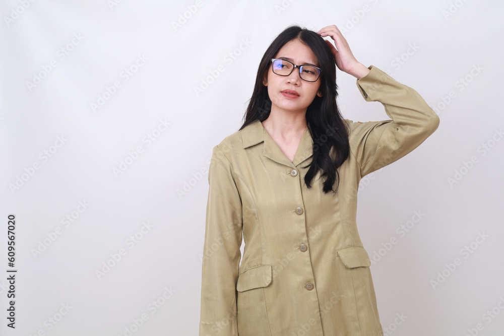 Confused young civil servant woman standing while holding her head and glancing sideways Confused young civil servant woman standing while holding her head and glancing sideways
