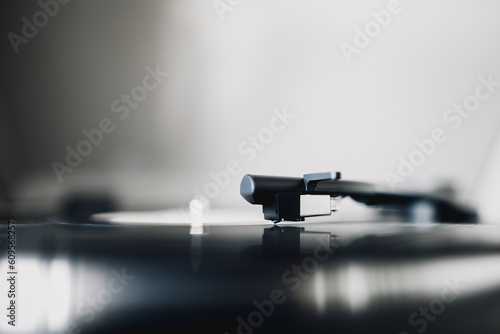 The needle of a vinyl record player in close up while an album is being played 