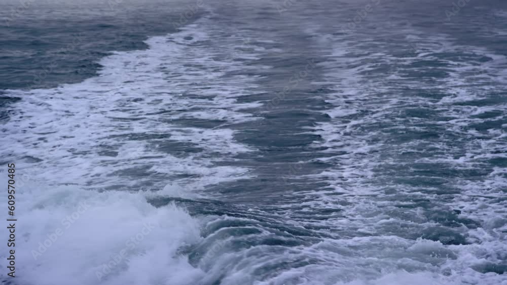 Ocean wake trails behind boat in early morning dawn, slow motion Ocean wake trails behind boat in early morning dawn, slow motion