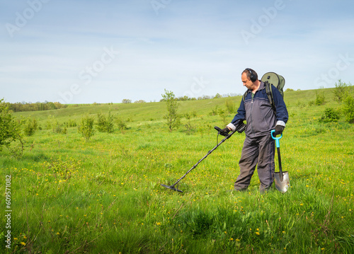 Archaeologist with metal detector. Man archaeologist is search for burial concept. Employee archaeological expedition holds metal detector. Guy with shovel and metal sensor. Underground coin detector