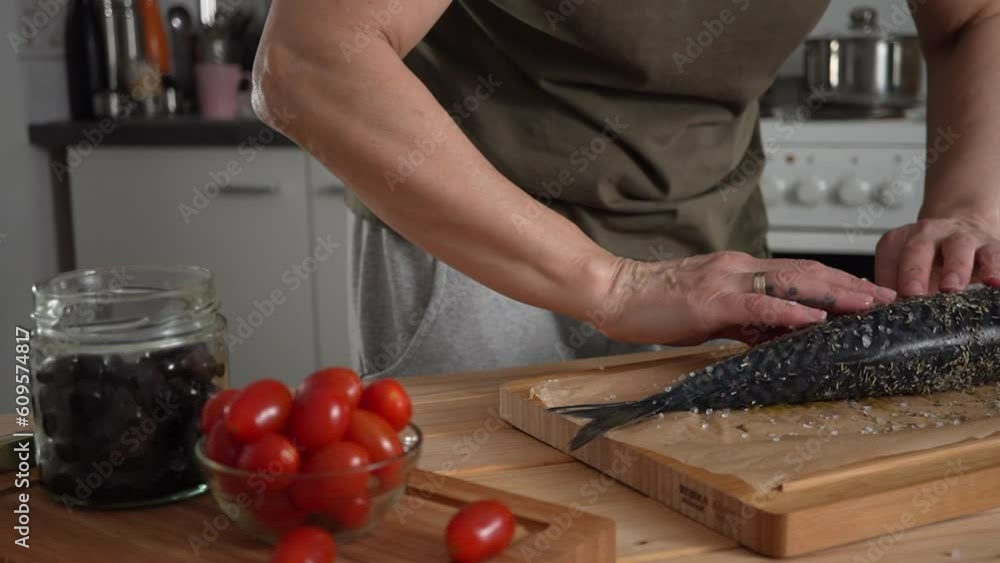 The woman puts the fish in the oven. Homemade baked fish The woman puts the fish in the oven. Homemade baked fish