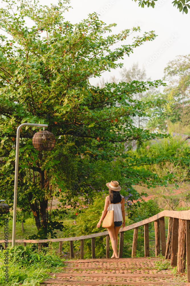 Naklejka premium Young woman step down by wooden stair in garden