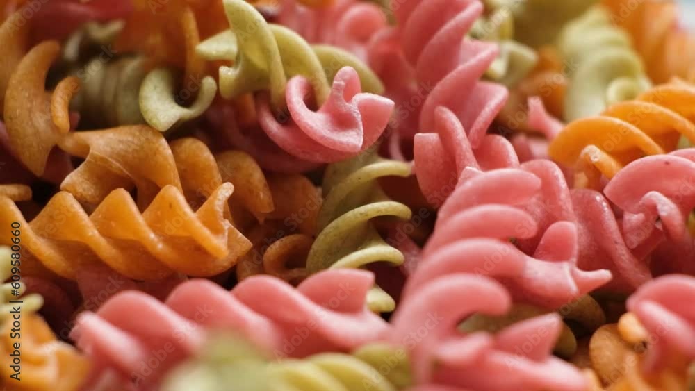 Rice vegetable pasta in the form of spirals, top view. Healthy rice pasta with tomatoes, celery, carrots and beets Rice vegetable pasta in the form of spirals, top view. Healthy rice pasta with tomatoes, celery, carrots and beets