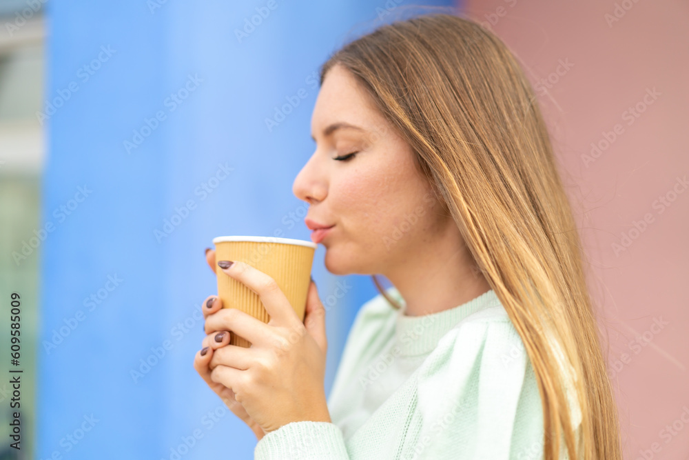 Young pretty blonde woman holding a take away coffee Young pretty blonde woman holding a take away coffee