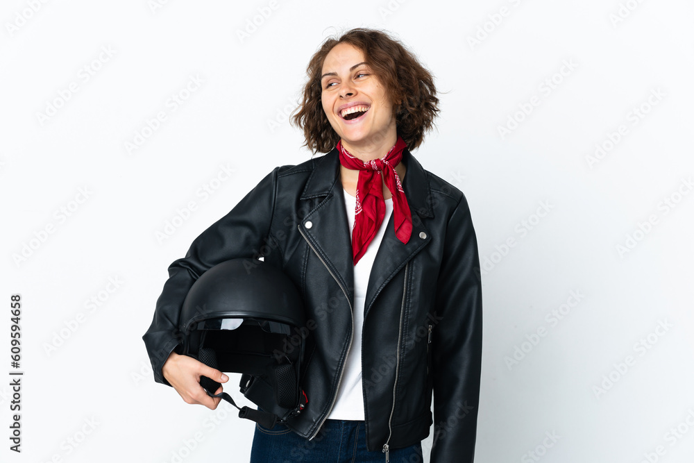English woman holding a motorcycle helmet isolated on white background posing with arms at hip and smiling English woman holding a motorcycle helmet isolated on white background posing with arms at hip and smiling