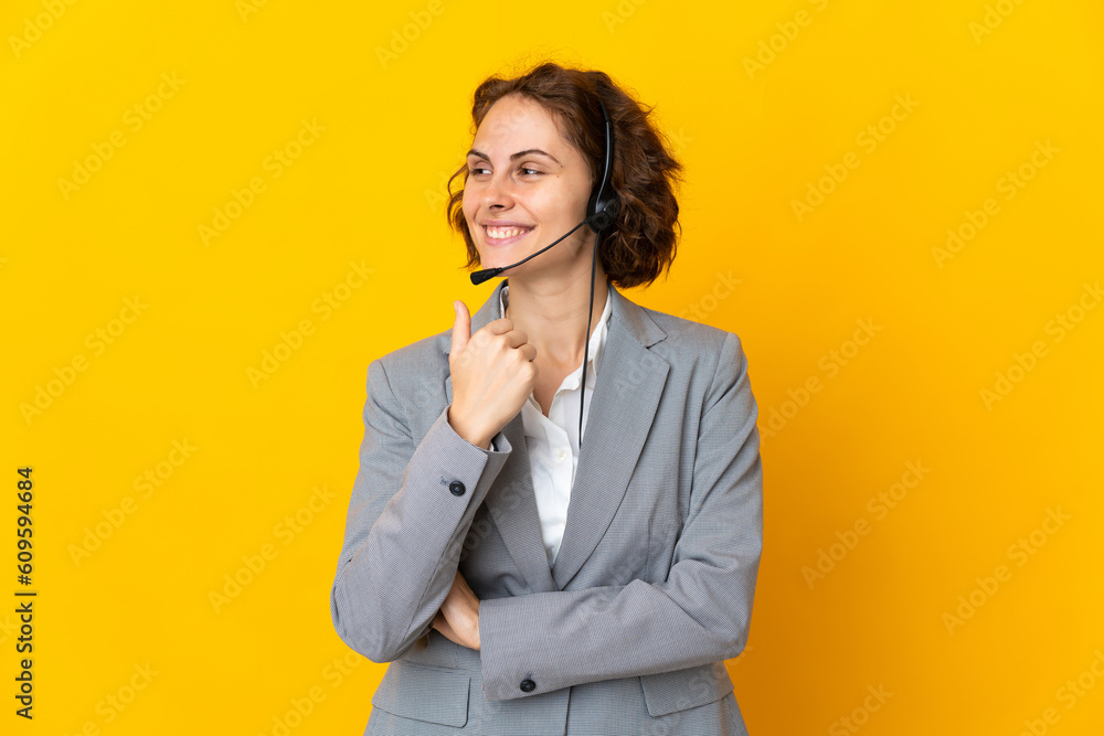 Young English woman isolated on yellow background pointing to the side to present a product Young English woman isolated on yellow background pointing to the side to present a product
