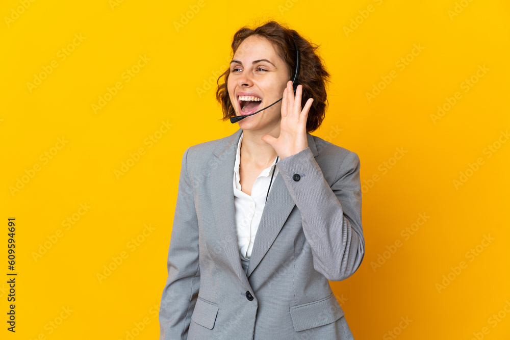 Young English woman isolated on yellow background shouting with mouth wide open to the side Young English woman isolated on yellow background shouting with mouth wide open to the side