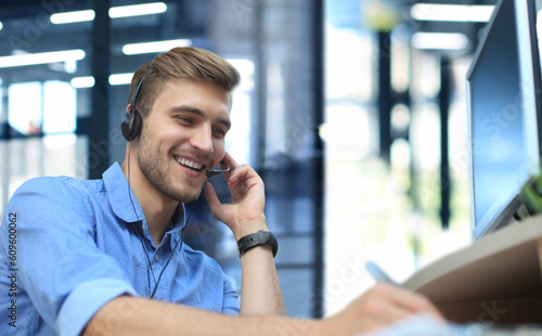 Smiling friendly handsome young male call centre operator photo