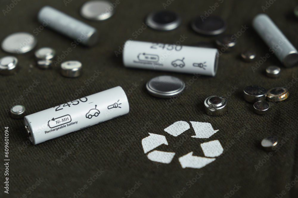 Flat lay with alkaline batteries on dark green background. Recycling