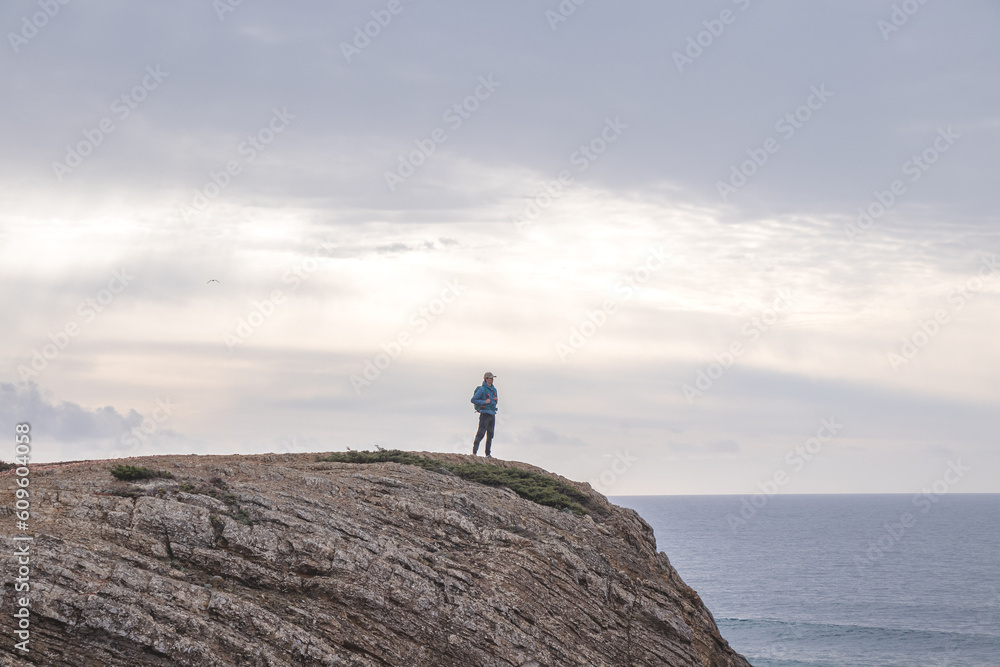 Travel enthusiast enjoys his freedom in the Portuguese countryside on the Atlantic coast observing the endless sea and the shapes of the cliffs. Wandering the Fisherman Trail