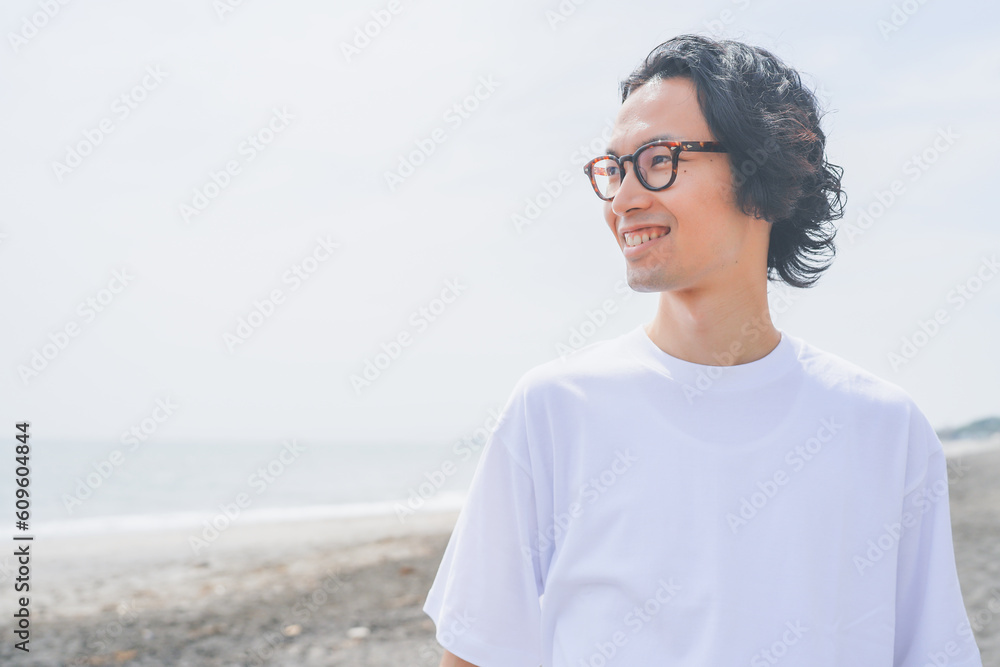 夏の海岸を歩くパーマヘアの男性 夏の海岸を歩くパーマヘアの男性