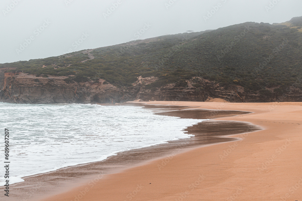 Wandering along the Fisherman Trail in the Algarve region of southwestern Portugal. Human footprints in the sandy surface