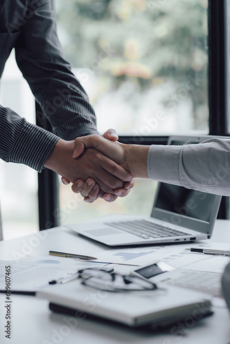 Two business people shake hands after a business deal is reached In the office area