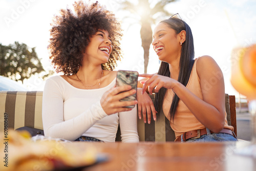 Laughing, happy and women with a phone at a cafe for a meme or social media notification. Smile, talking and friends with a mobile for a funny app, comic conversation or comedy together at restaurant