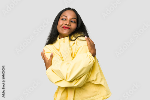 Young Indian woman cut out isolated on white background hugs, smiling carefree and happy. © Asier