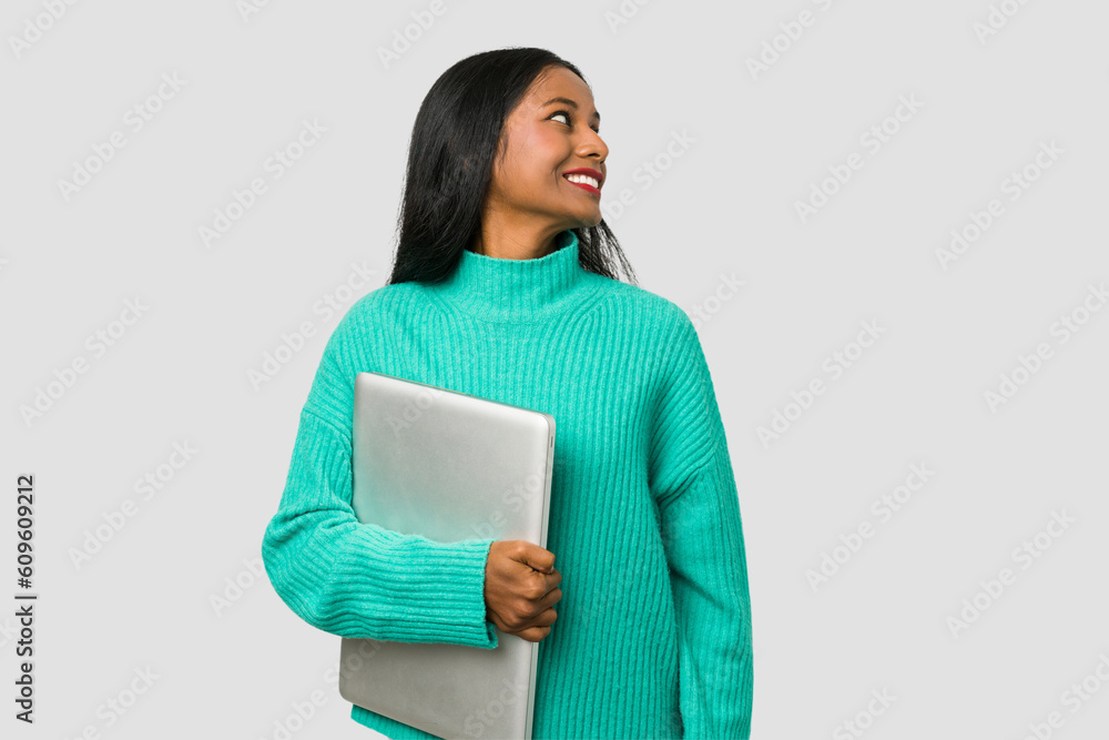 Young indian woman holding a laptop isolated on white background Young indian woman holding a laptop isolated on white background