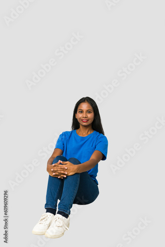 Young Indian woman sitting on the floor isolated on white background