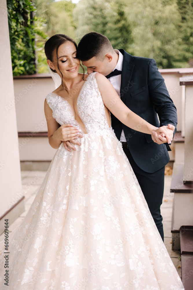 Portrait of newlyweds stand on balcony and dreaming. Handsome groom and beautiful bride on their wedding day Portrait of newlyweds stand on balcony and dreaming. Handsome groom and beautiful bride on their wedding day