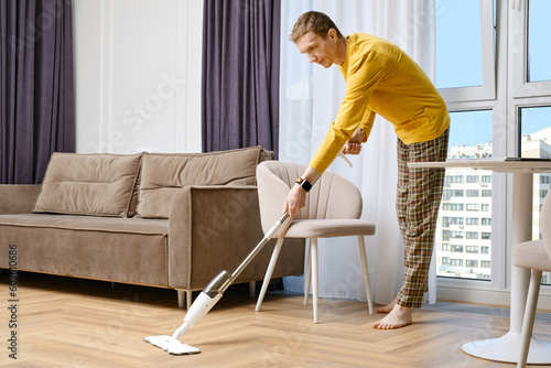 Middle age caucasian man cleaning floor at home