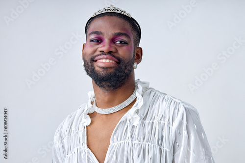 Half Body Portrait of happy 20-25 black bearded man with dark skin of american ethnicity in white sweet shirt and crown. Gay wear fashion style and poses over white studio Background isolated photo