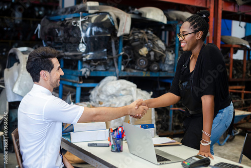 Male customers shake hands with female cashier african american accept payment auto parts trading. Completion of joint business agreements between partners. Business connection concept.