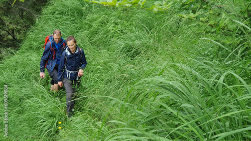 Couple of hikers walking in big grass