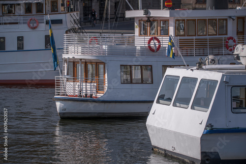 Stern of archipelago ferries moored at a pier in the bay Nybroviken, a sunny summer day in Stockholm