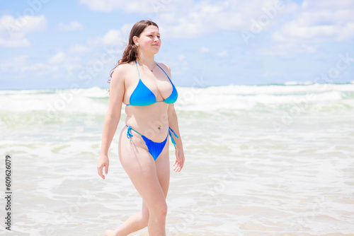 砂浜を歩く水着のセクシーなオーストラリア人女性